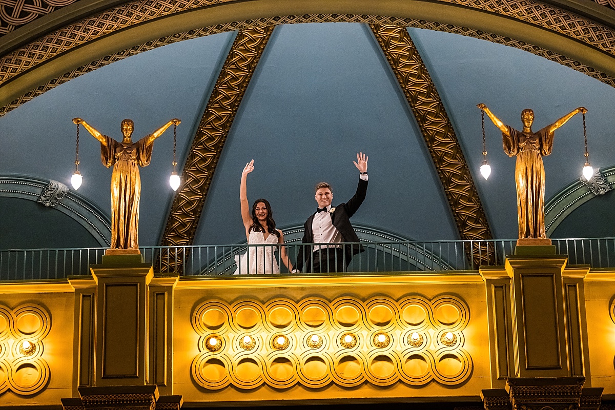 bride and groom waving from balcony in beautiful St. Louis Union Station wedding photo